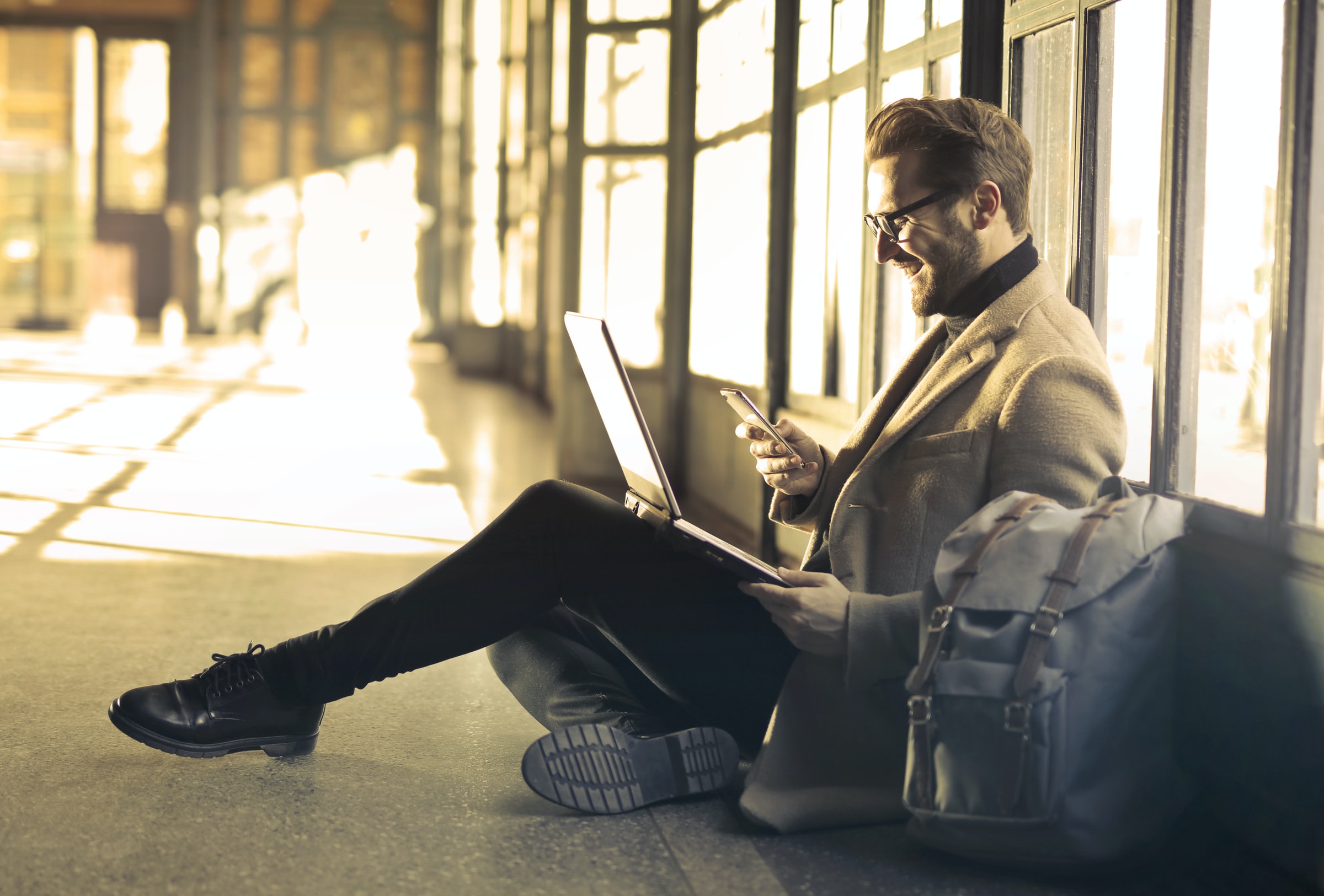 Un homme avec son laptop dans une gare